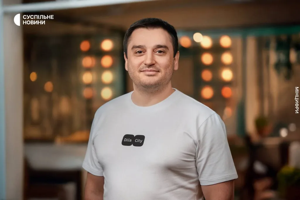 Чоловік у футболці Дія City усміхається