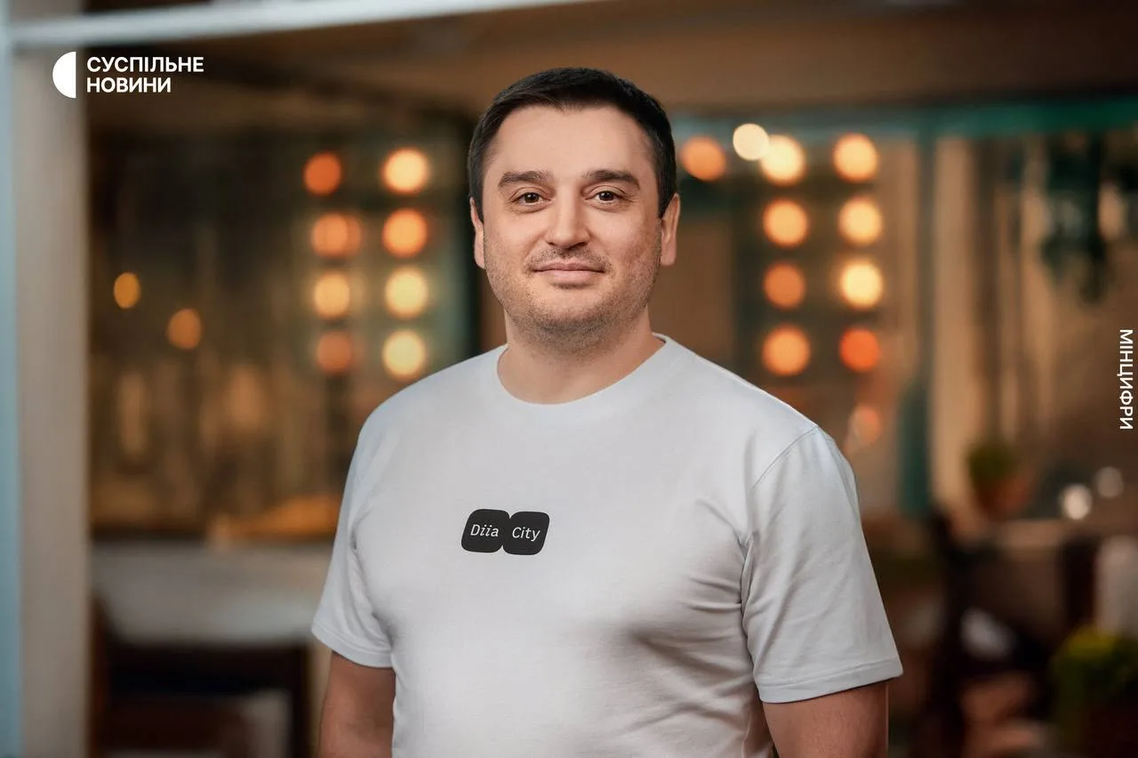 Чоловік у футболці Дія City усміхається