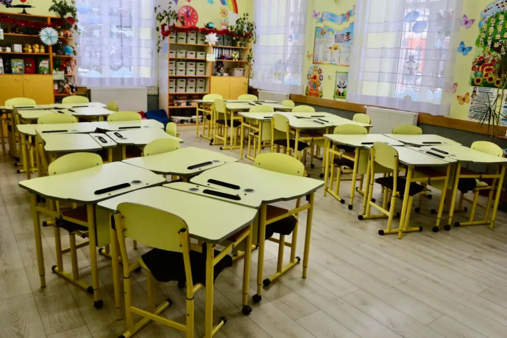 Яскравий клас із жовтими партами та декором