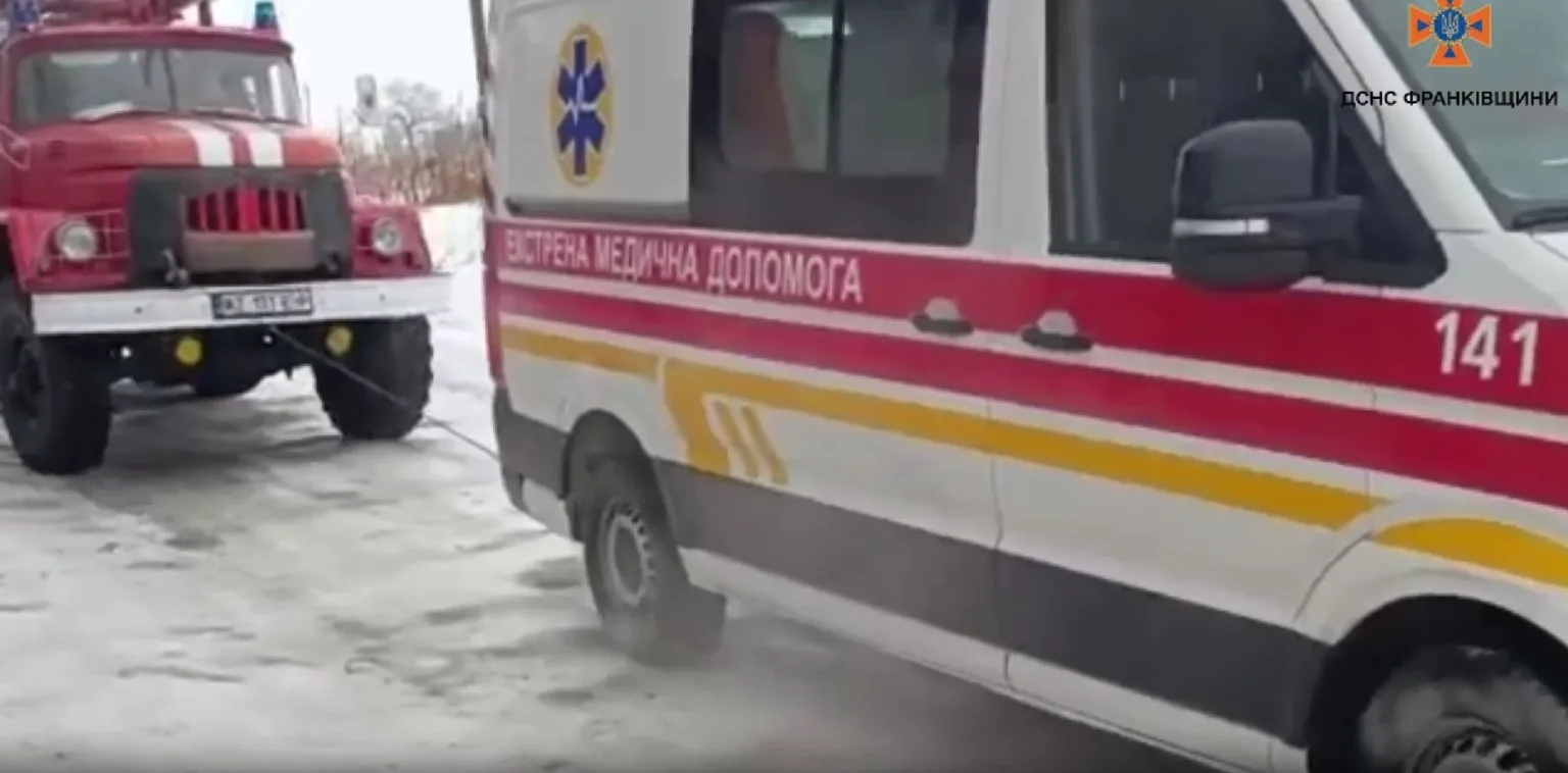 Пожежна машина допомагає швидкій на засніженій дорозі