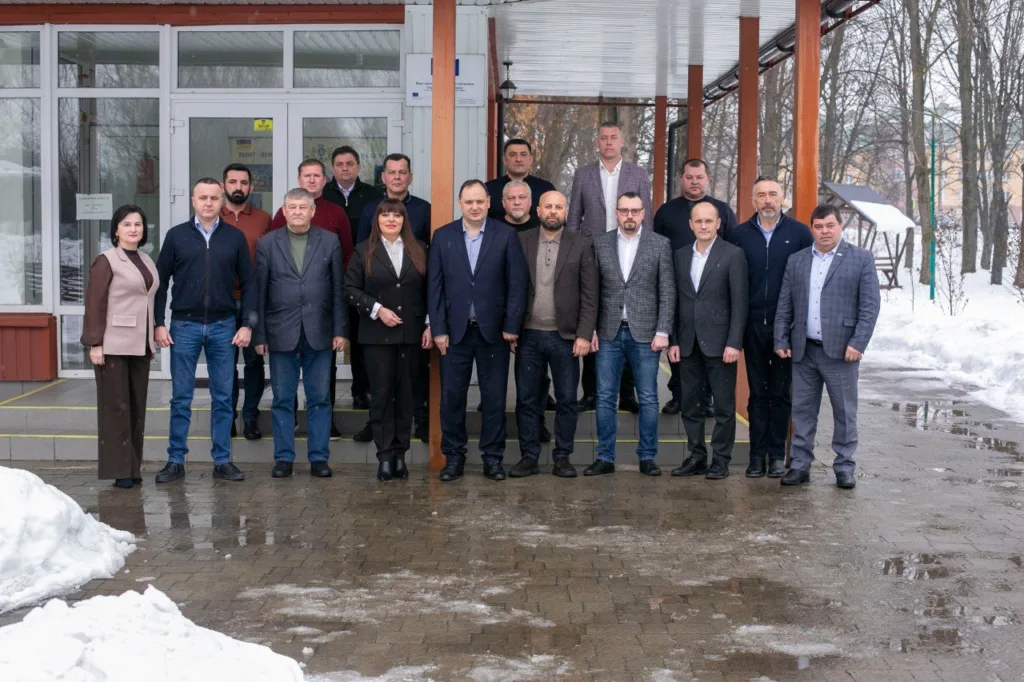 Група людей стоїть перед будівлею взимку