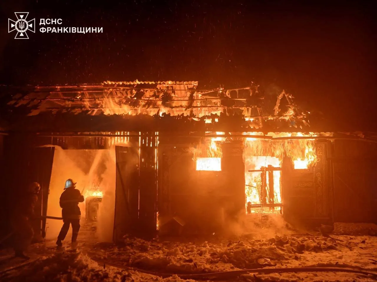 Пожежники гасять палаючий будинок уночі