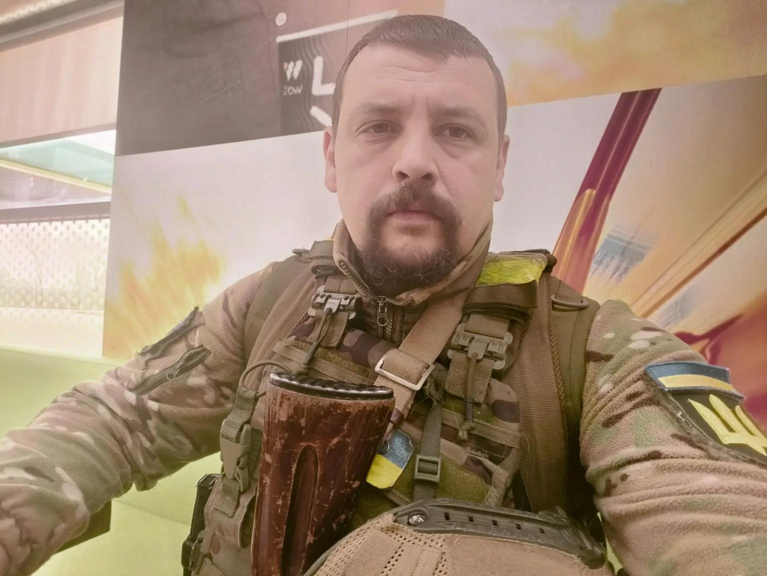 Український військовий у камуфляжі з прапором України