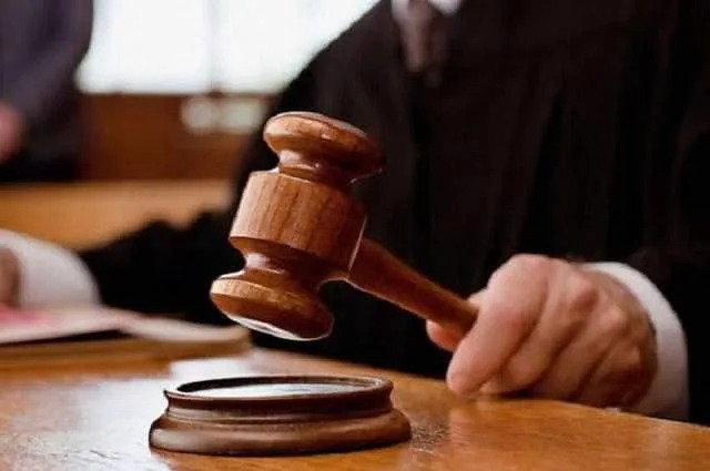 Суддя тримає молоток у залі суду