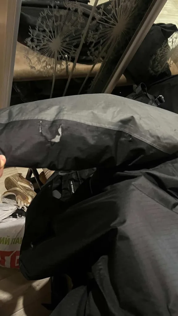 Пошкоджена чорна куртка з розірваним рукавом