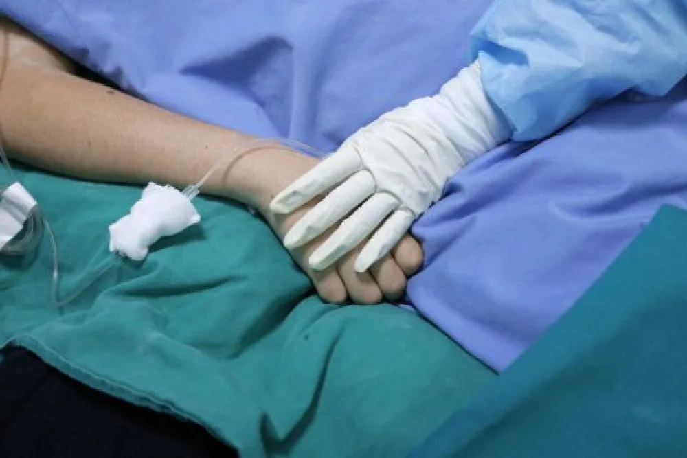 Медик тримає руку пацієнта в лікарні