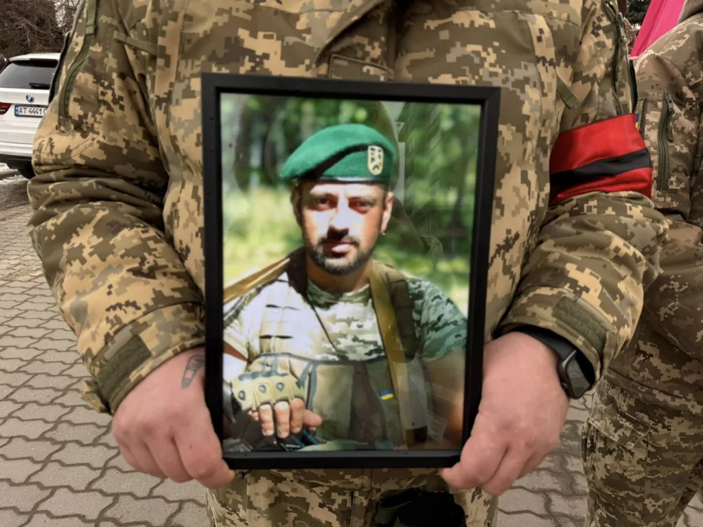 Військовий тримає фото загиблого солдата