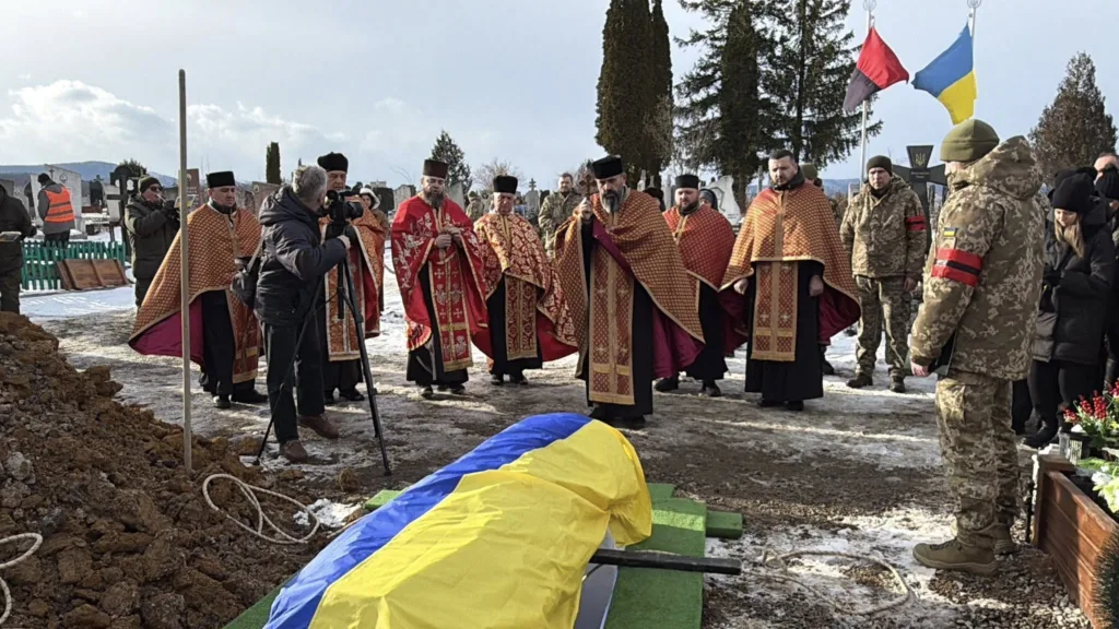 Похорон військового з українським прапором і священиками