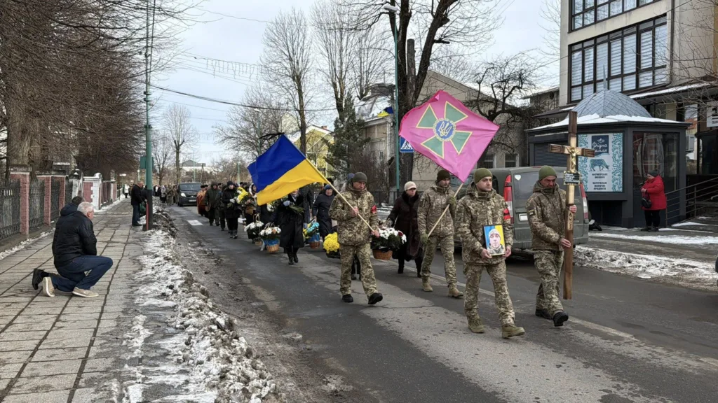 Військові несуть прапори та вінки на похороні