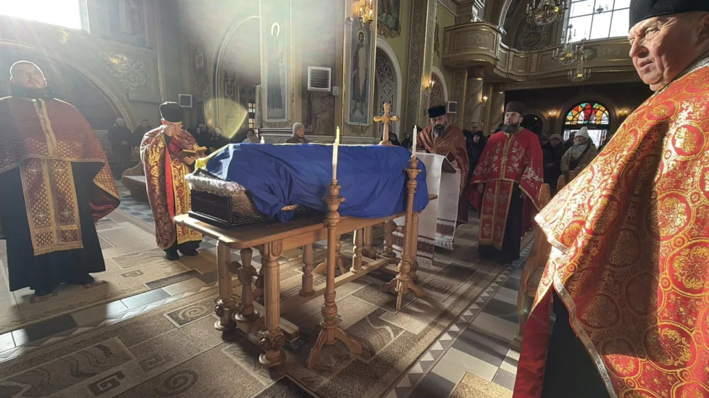 Священники проводять церемонію в церкві біля труни