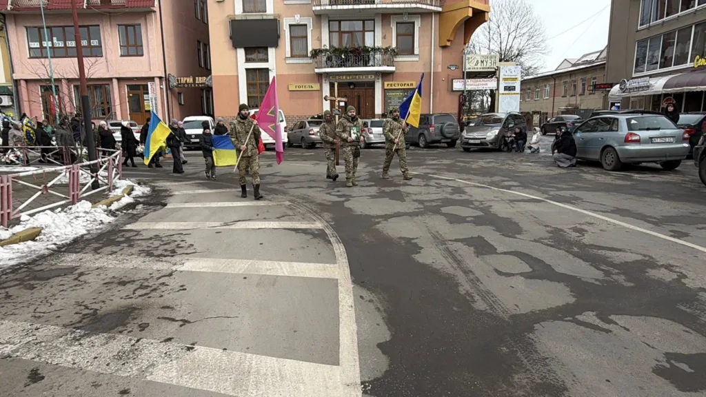 Військові з українськими прапорами на міській вулиці