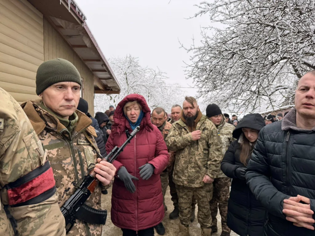 Військові та люди під час зимової церемонії прощання