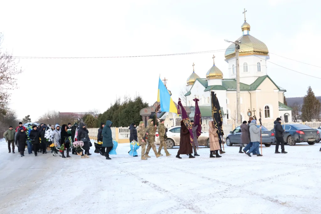 Похоронна процесія біля православної церкви взимку