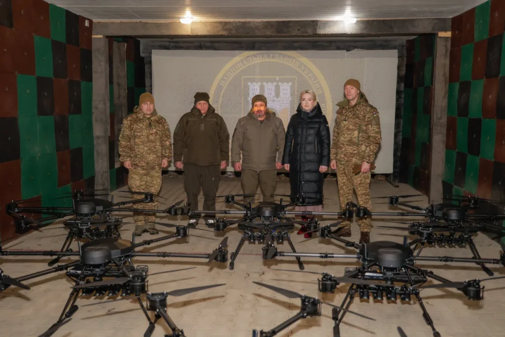 Військові представники стоять біля великих дронів