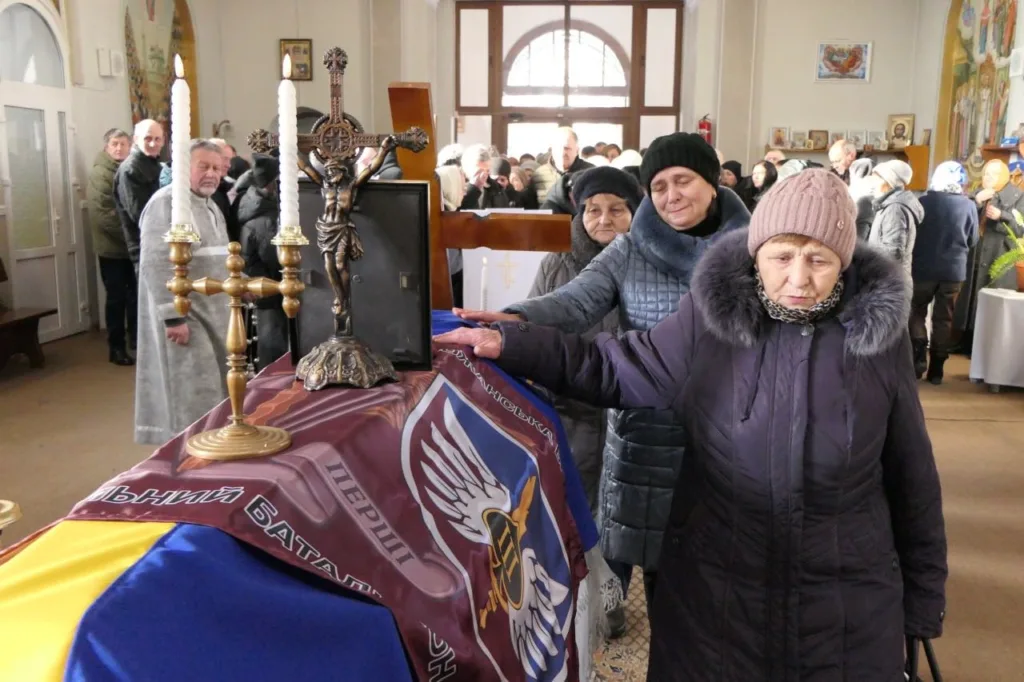 Люди прощаються із загиблим військовим у церкві