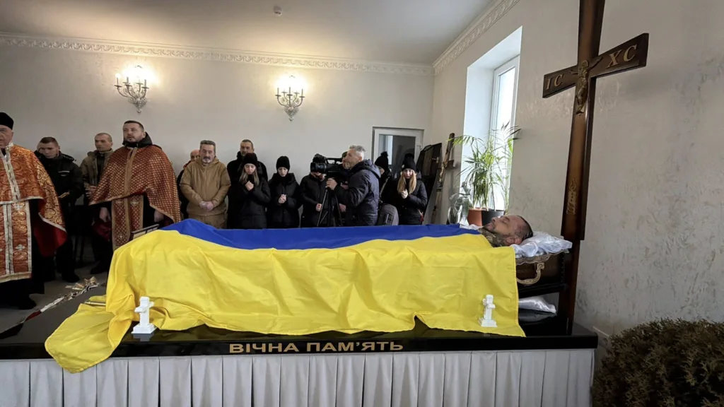 Прощання із загиблим воїном, накритим прапором України