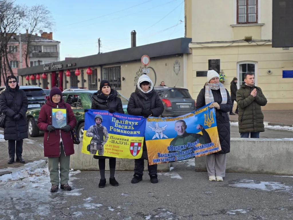 Люди тримають плакат на підтримку зниклих військових