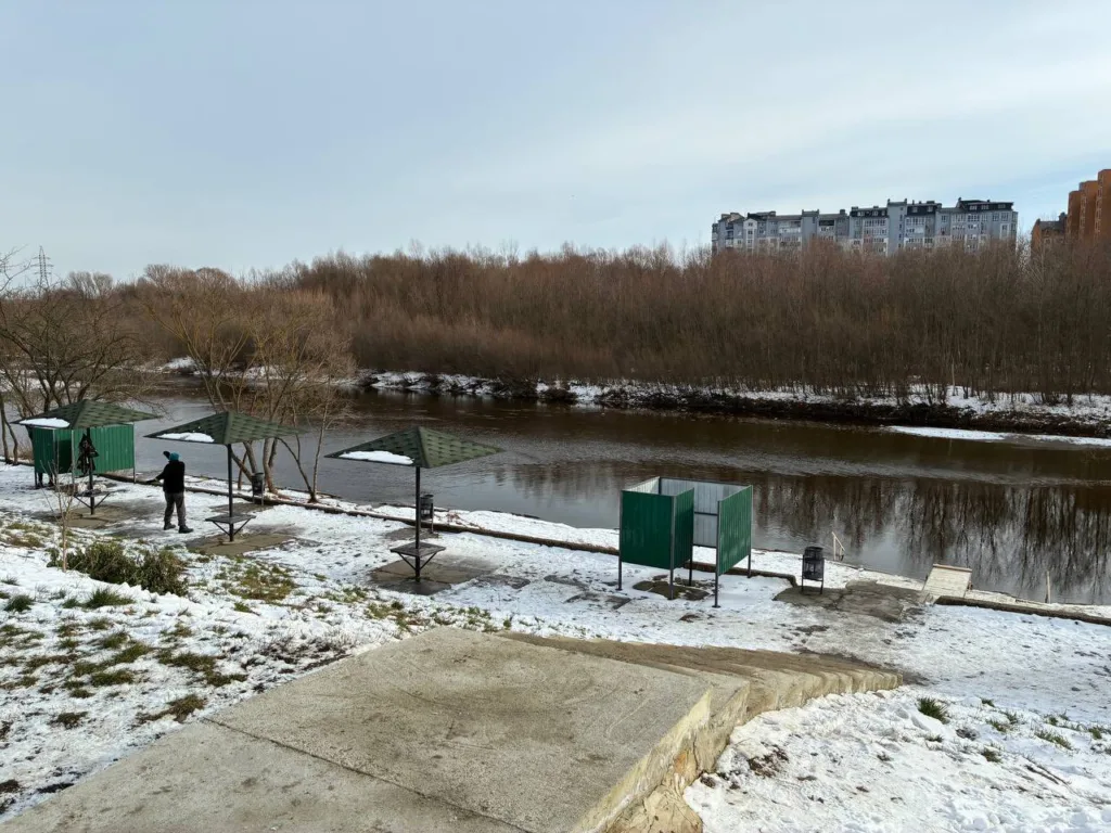 Зимовий берег річки з альтанками та деревами