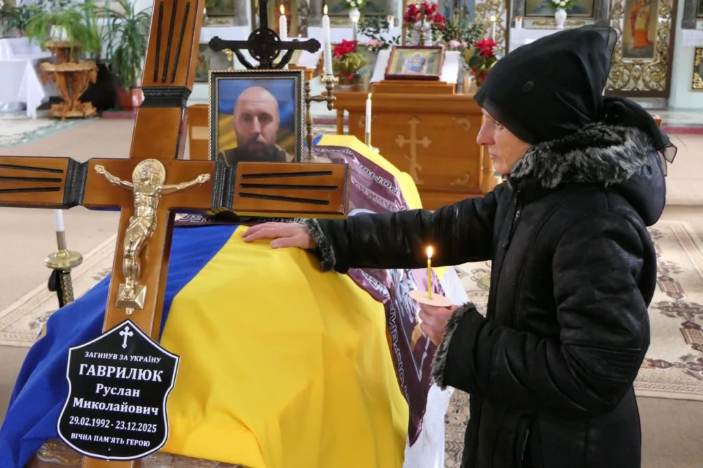 Жінка прощається із загиблим військовим у церкві