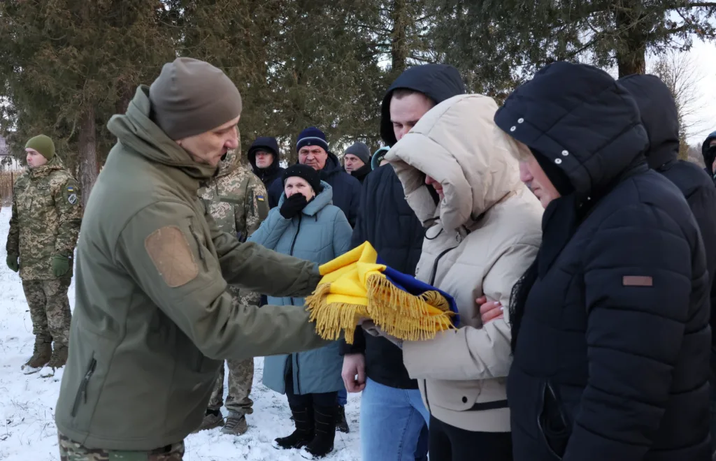 Військові передають український прапор близьким загиблого