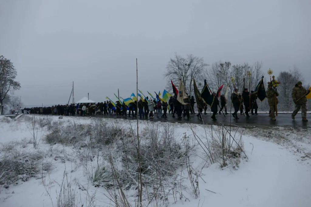 Зимова хода з українськими прапорами на снігу