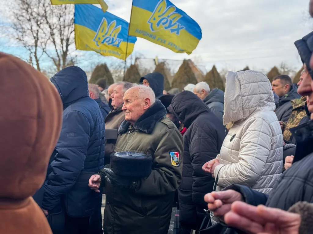 Люди на мітингу з прапорами України