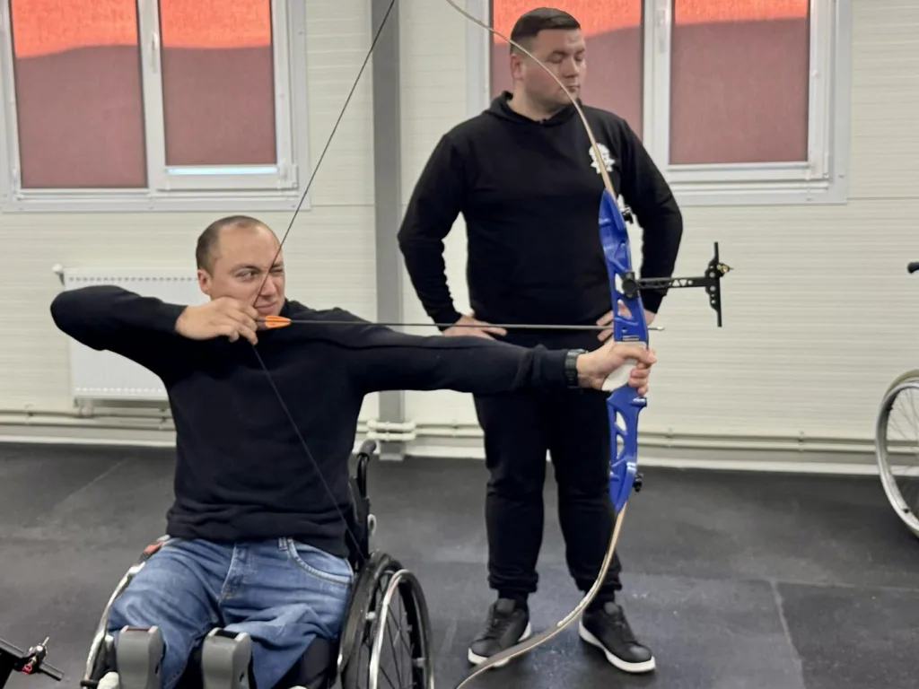 Чоловік на візку тренується стрільбі з лука