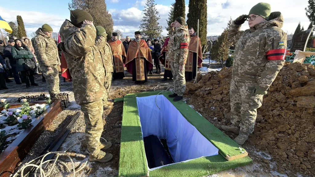 Військові віддають честь на похороні героя