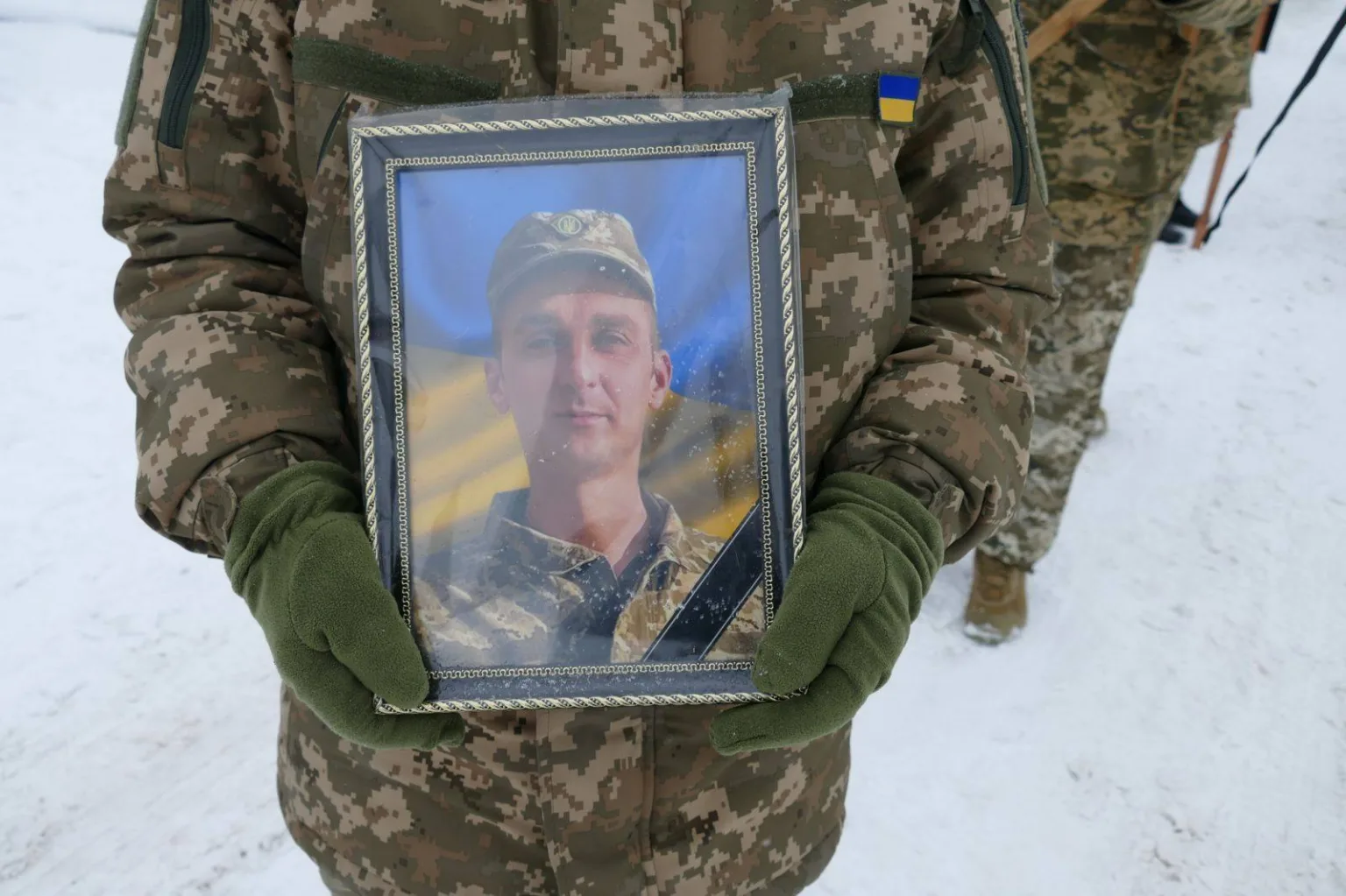 Військовий тримає фото загиблого героя України