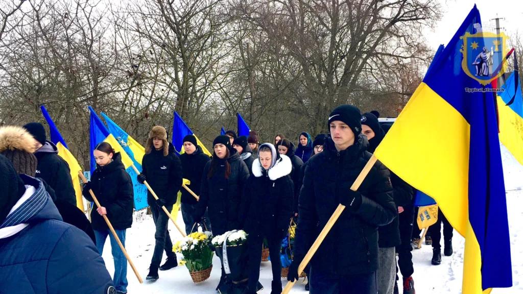 Люди з українськими прапорами на зимовій ході