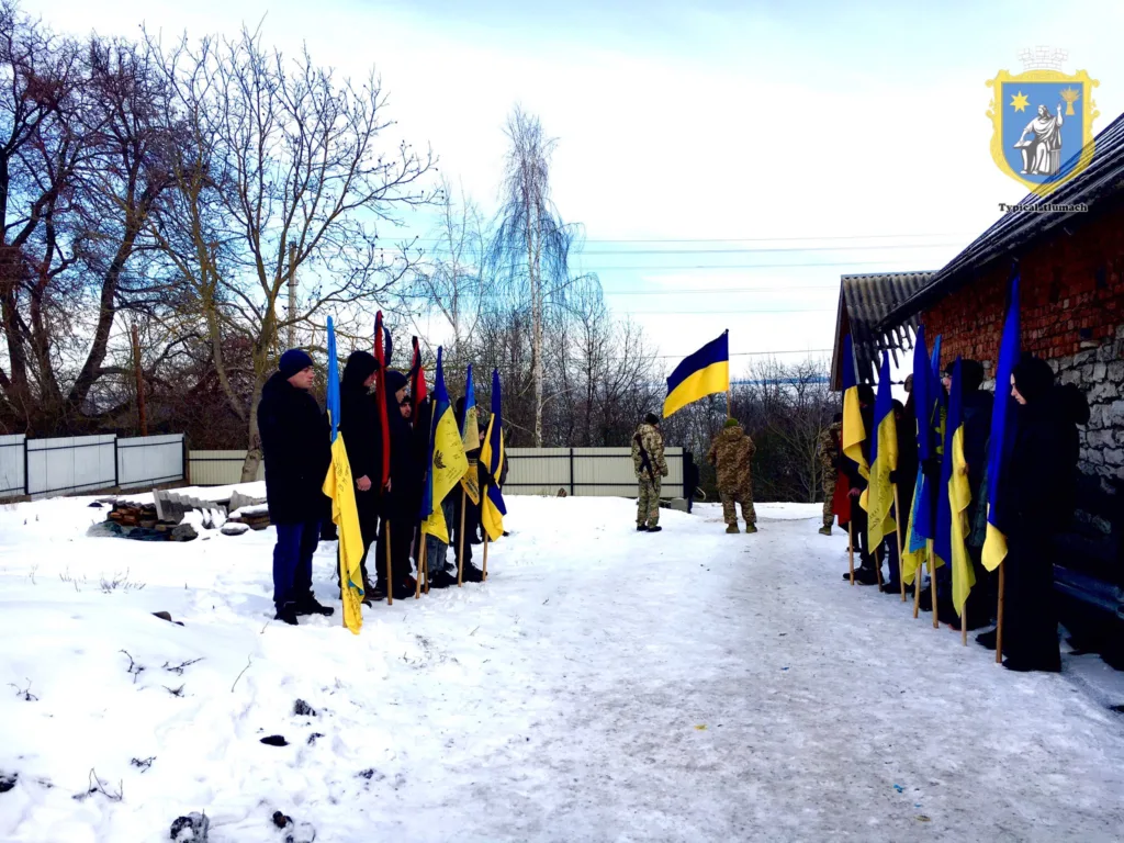 Люди з українськими прапорами на снігу