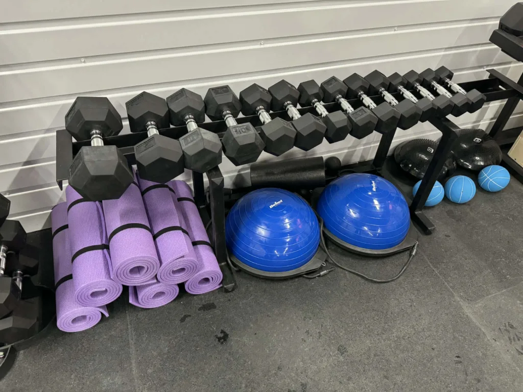 Гантелі, килимки та фітнес-м'ячі в спортзалі