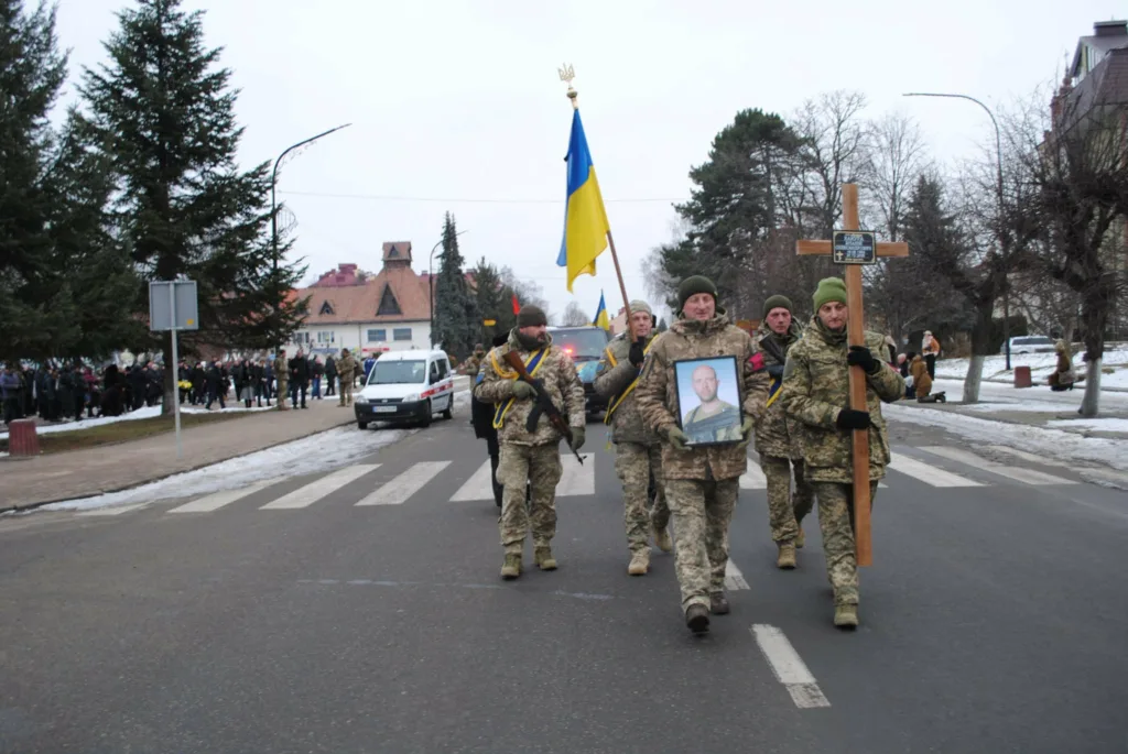 Військові несуть прапор і фото загиблого героя