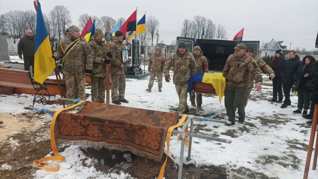 Військові несуть труну з українським прапором на похороні