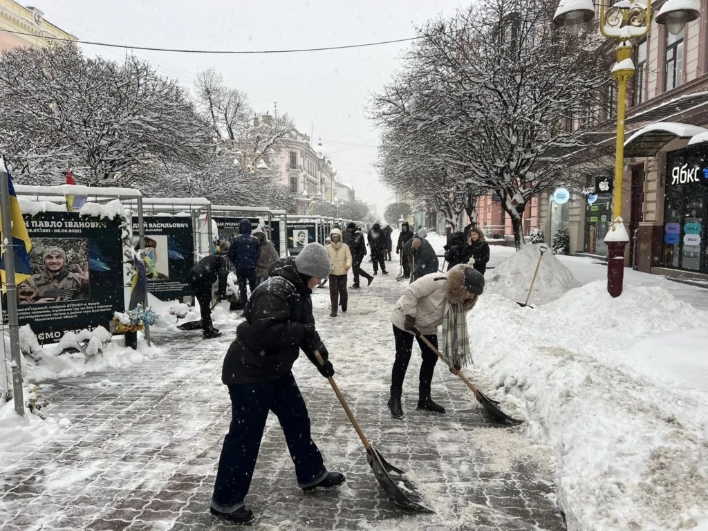 Люди розчищають сніг на міській вулиці взимку