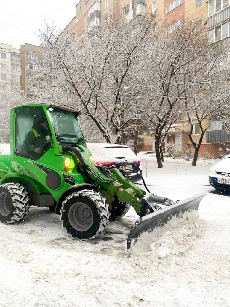 Трактор прибирає сніг на міській вулиці