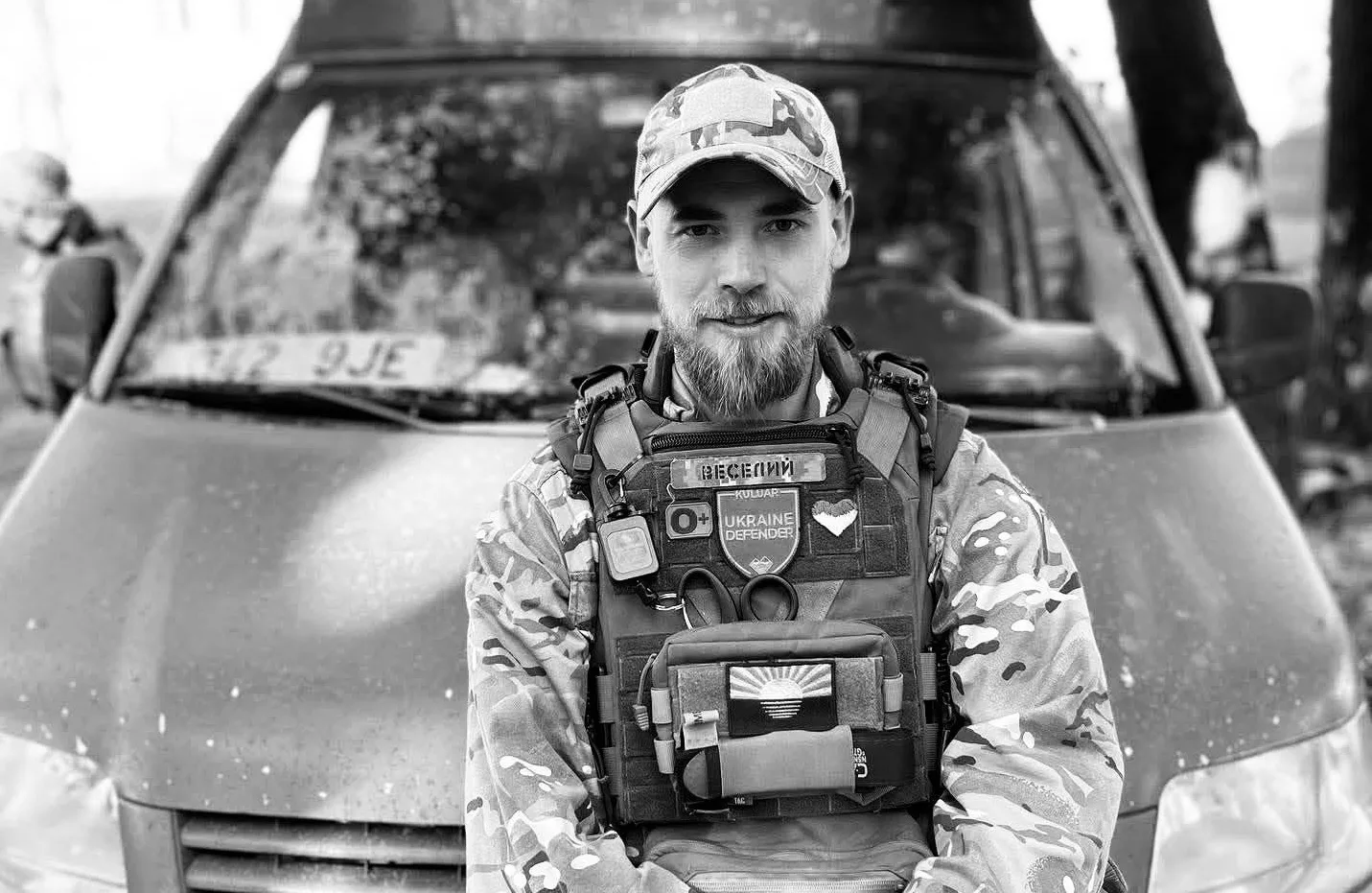 Український військовий у формі перед автомобілем