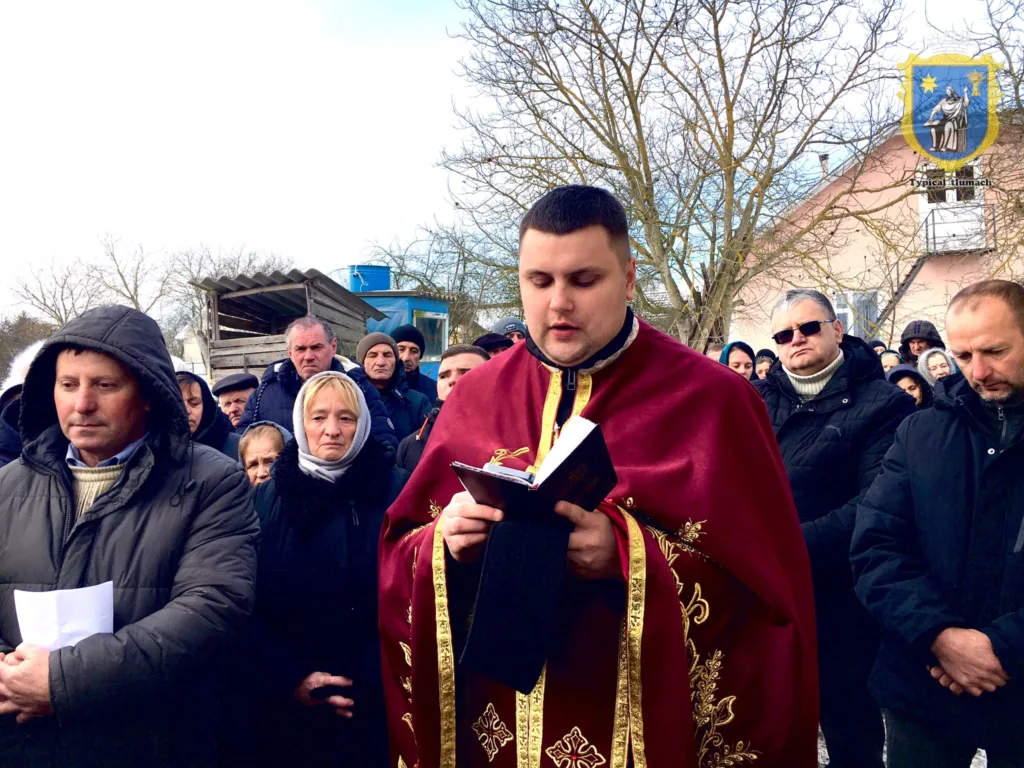 Священник молиться з людьми на вулиці