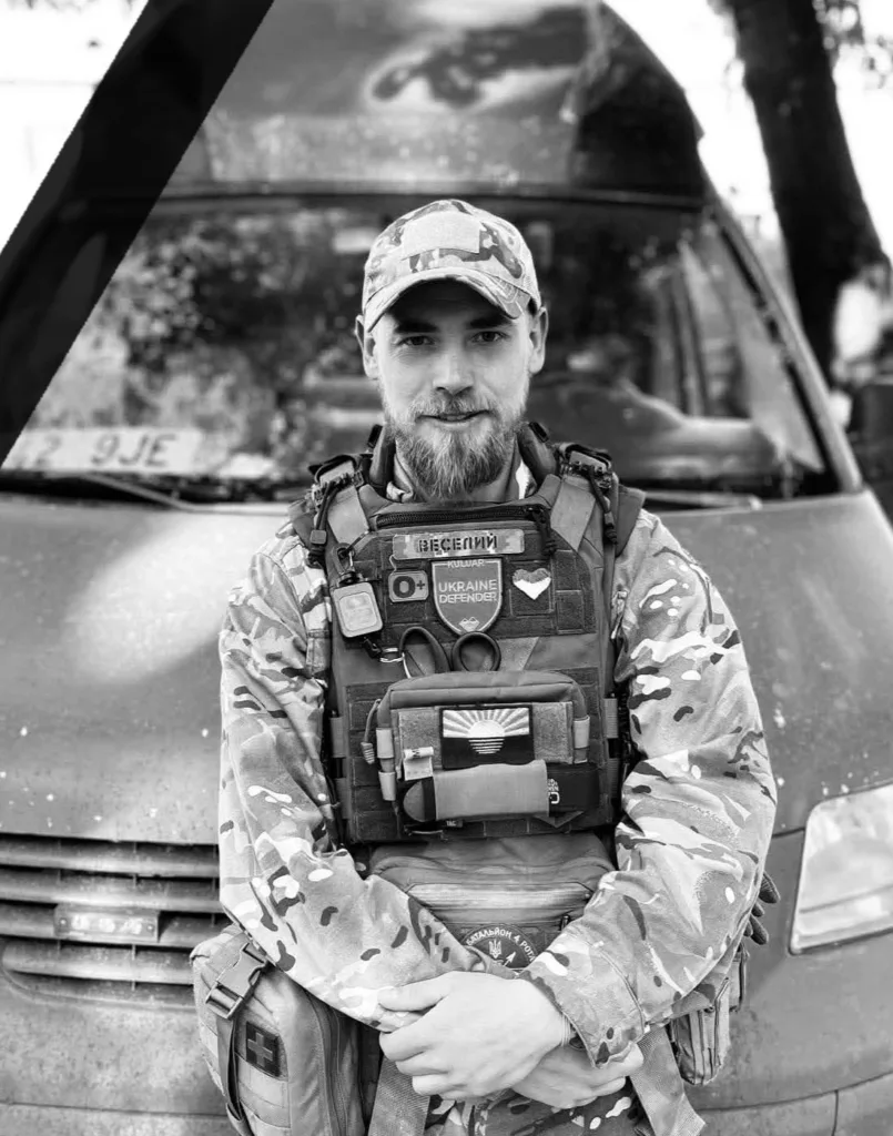 Український військовий у формі перед автомобілем