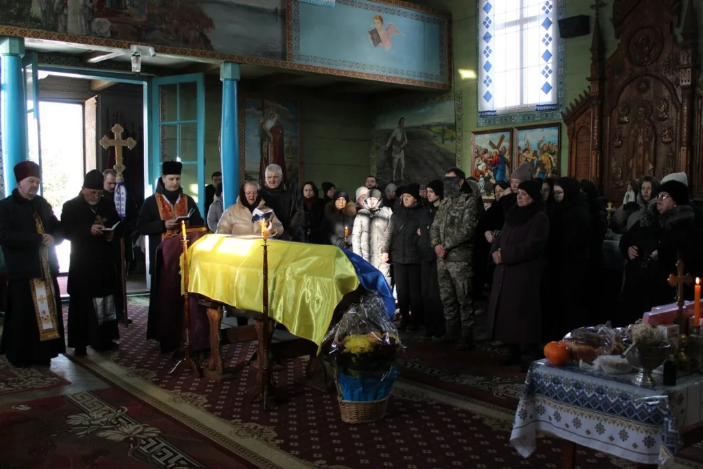Прощання з військовим у церкві під українським прапором