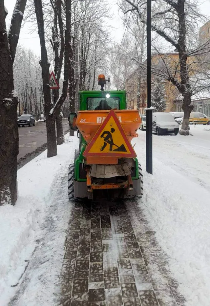 Трактор прибирає сніг на міській вулиці