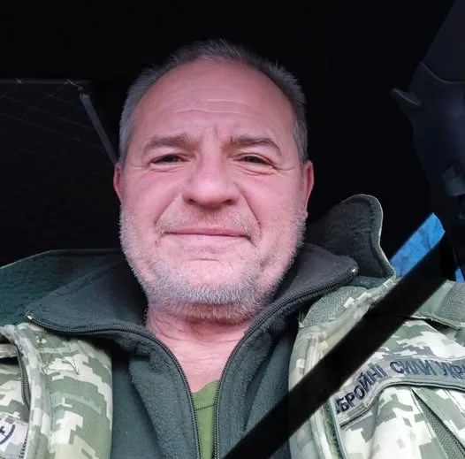 Військовий чоловік у камуфляжі посміхається в авто