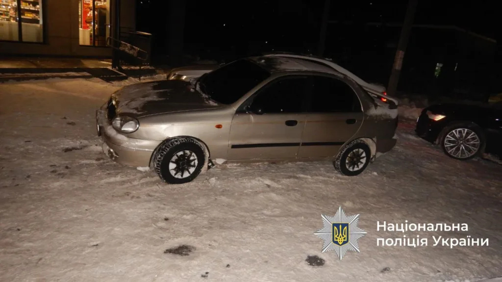 Автомобіль на засніженій вулиці біля магазину