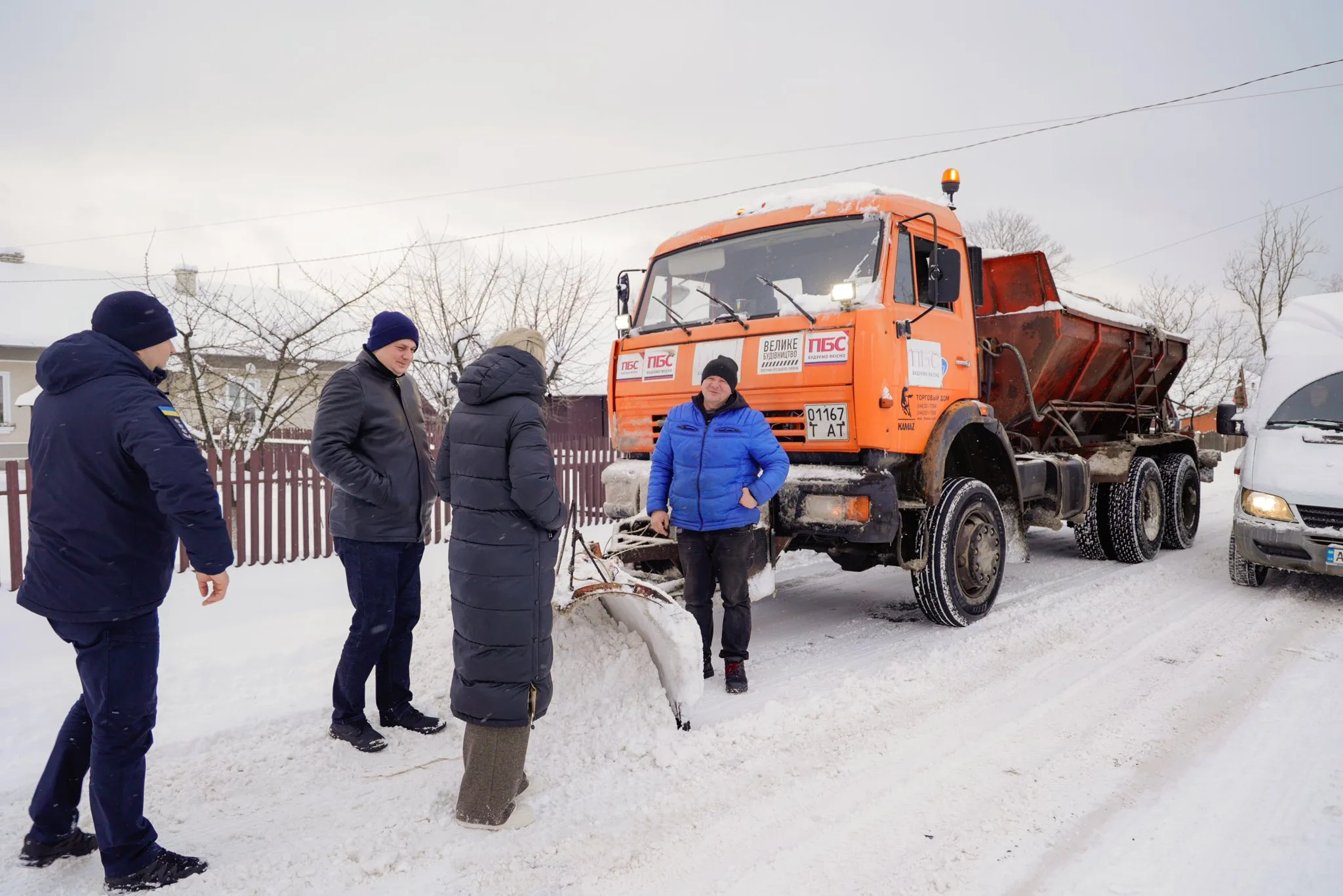 Люди біля снігоприбиральної машини на зимовій дорозі