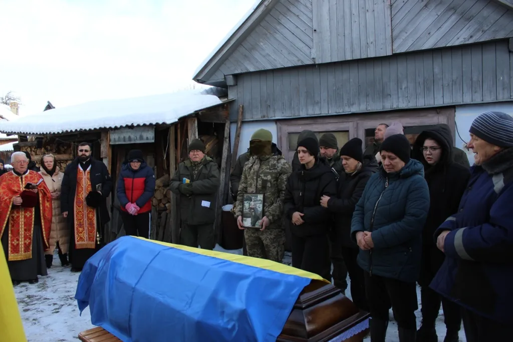 Похорон військового з труною під українським прапором