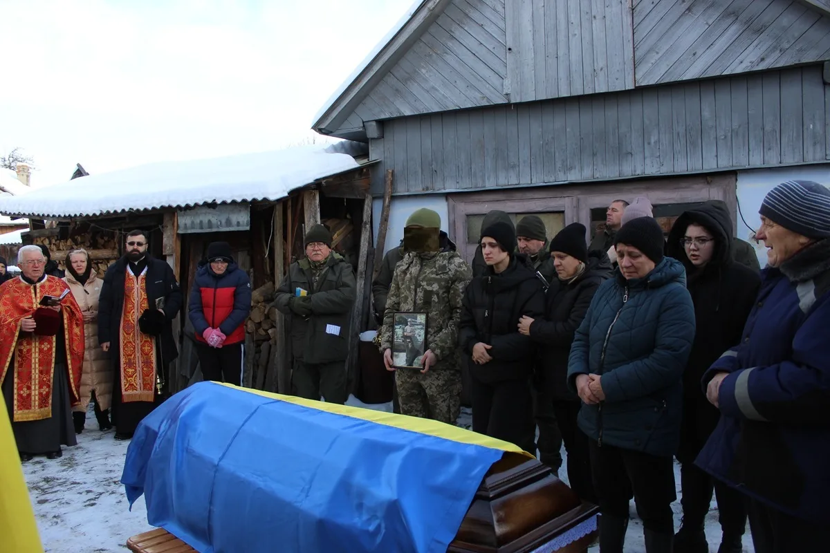 Похорон військового з труною під українським прапором