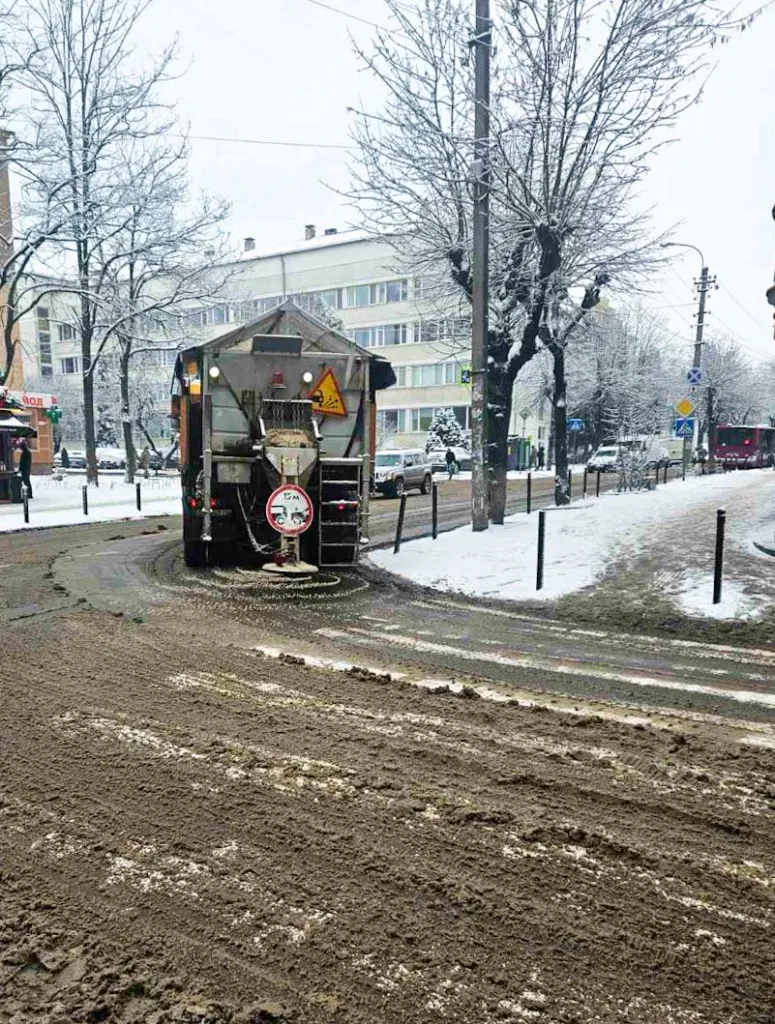 Машина посипає дорогу сіллю взимку