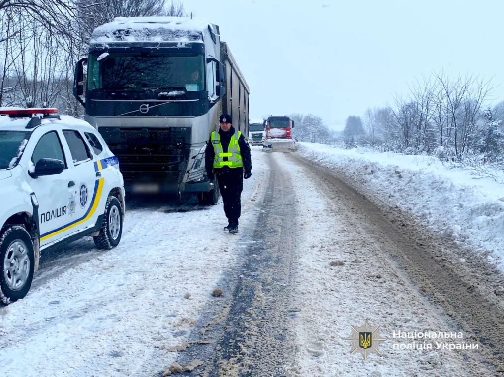 Поліція допомагає вантажівці на засніженій дорозі