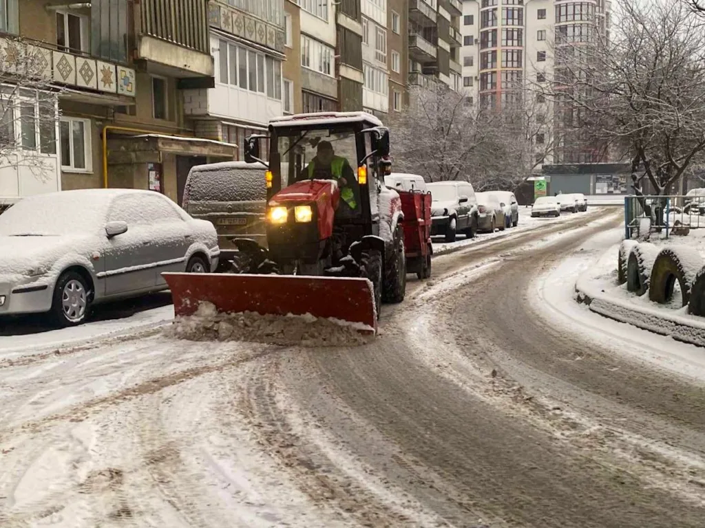 Трактор прибирає сніг на міській вулиці