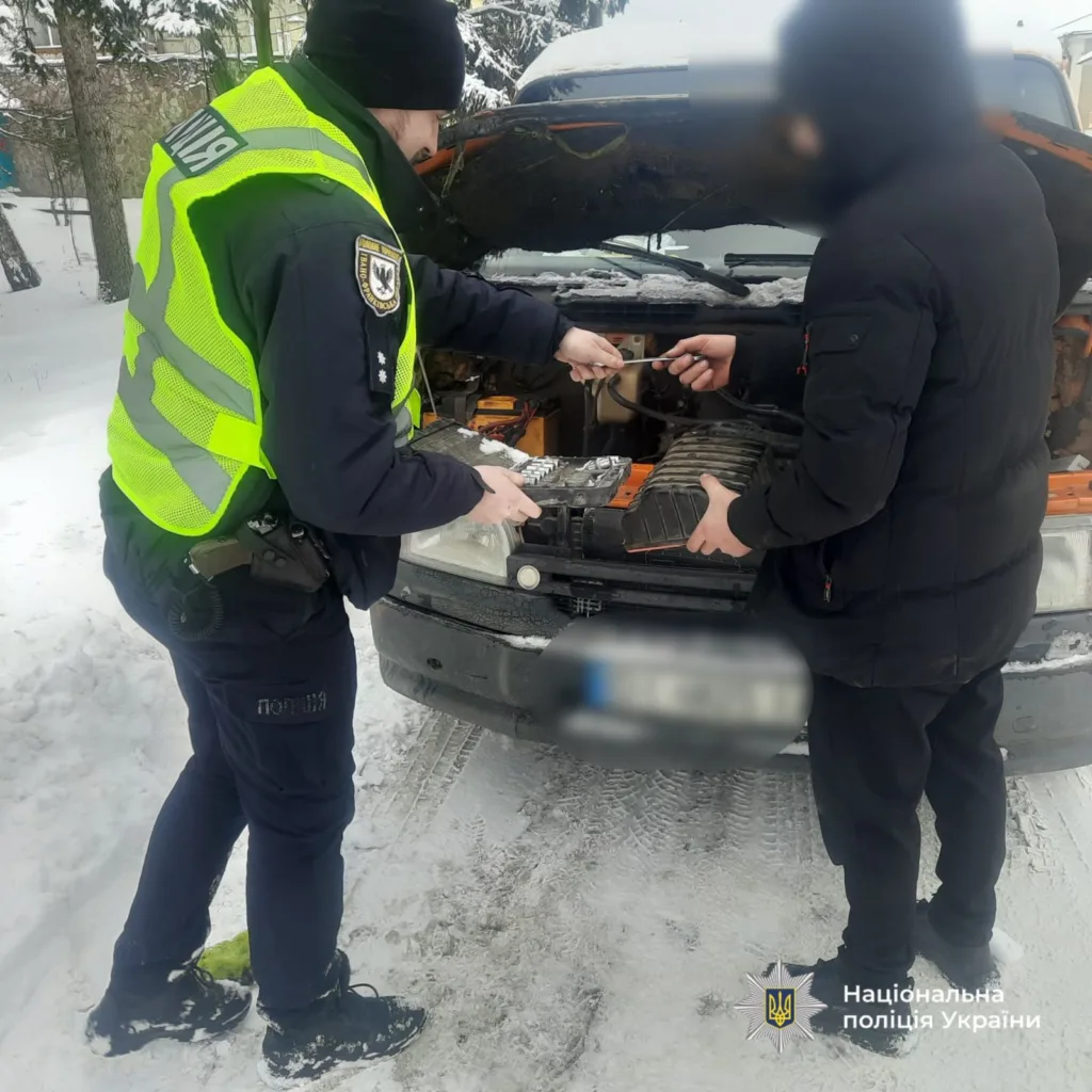 Поліцейський допомагає водієві завести автомобіль узимку